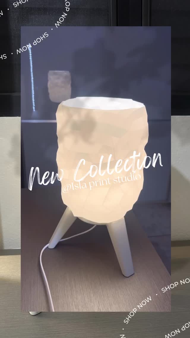 Lámpara geométrica blanca impresa en 3D y encendida sobre una mesa